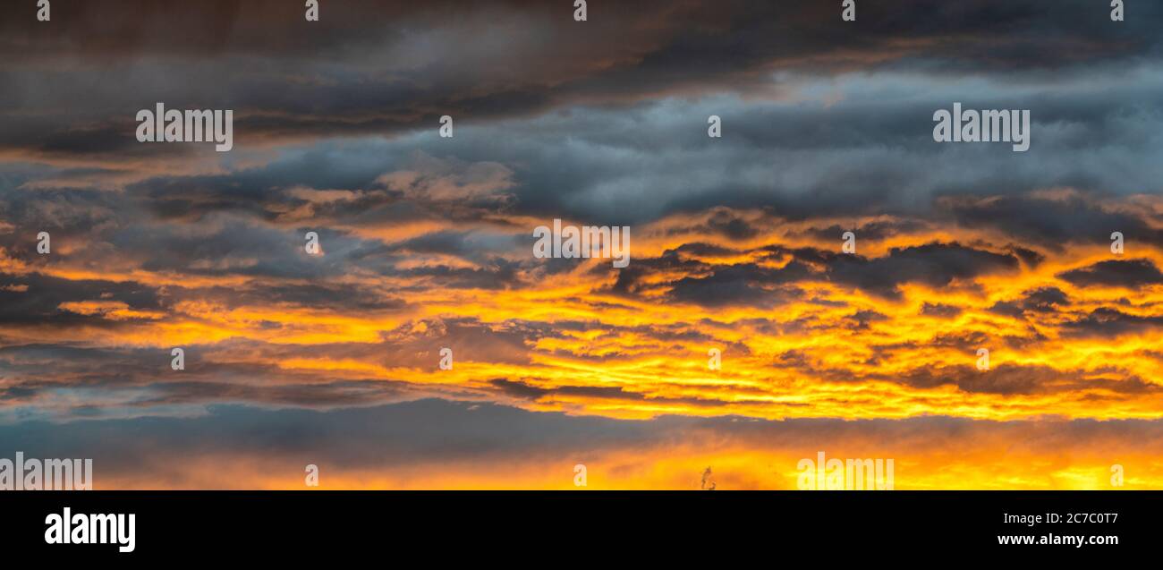 Clouds in the burning orange sky at sunset, Italy Stock Photo