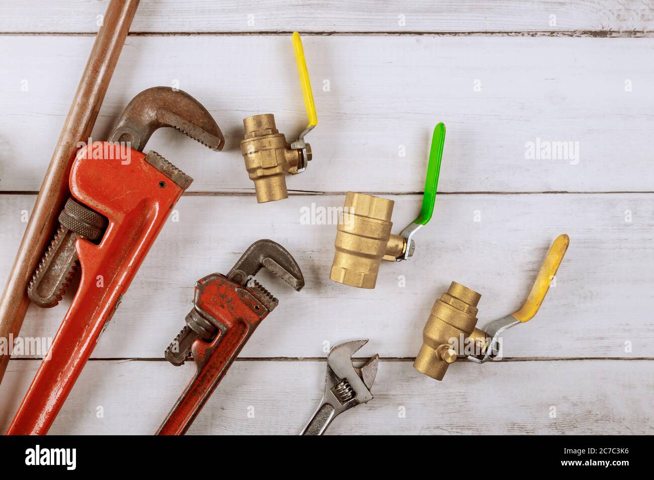Brass gate valve on wooden background, monkey wrench brass plumbing fittings Stock Photo