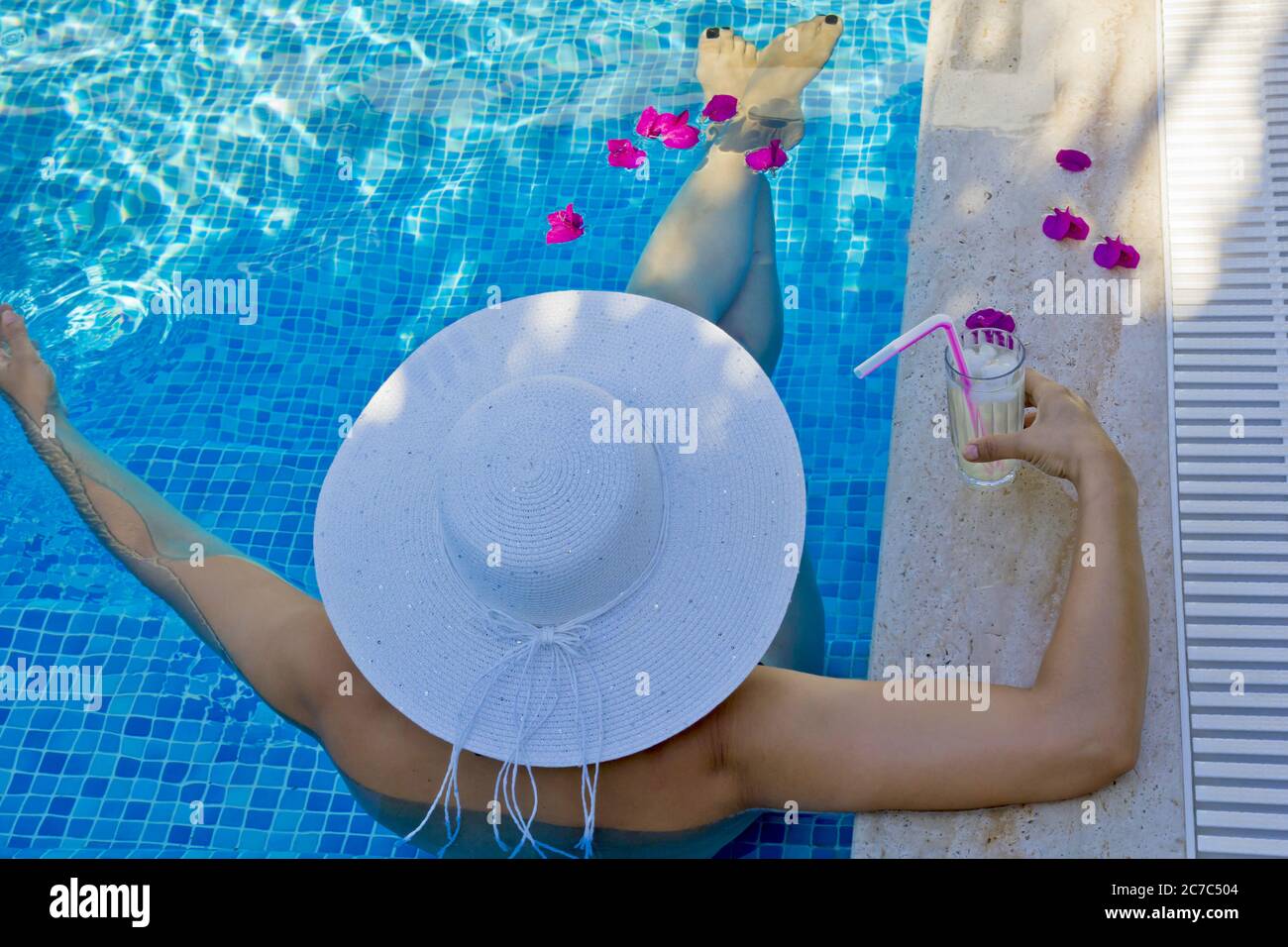 young woman in a white hat relaxing in the pool Stock Photo - Alamy