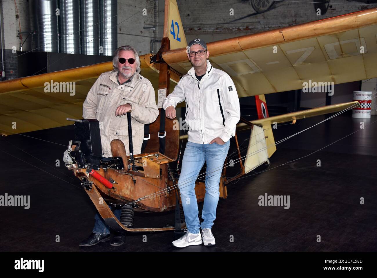 15 July 2020, North Rhine-Westphalia, Cologne: Musician Tommy Engel and comedian Marc Metzger, l-r, pose on a school glider SG 38, glider from 1942, during the presentation of the safety and hygiene concept of the dinner show 'Weihnachtsengel' which will be shown from 20.11.2020. Photo: Horst Galuschka/dpa Stock Photo