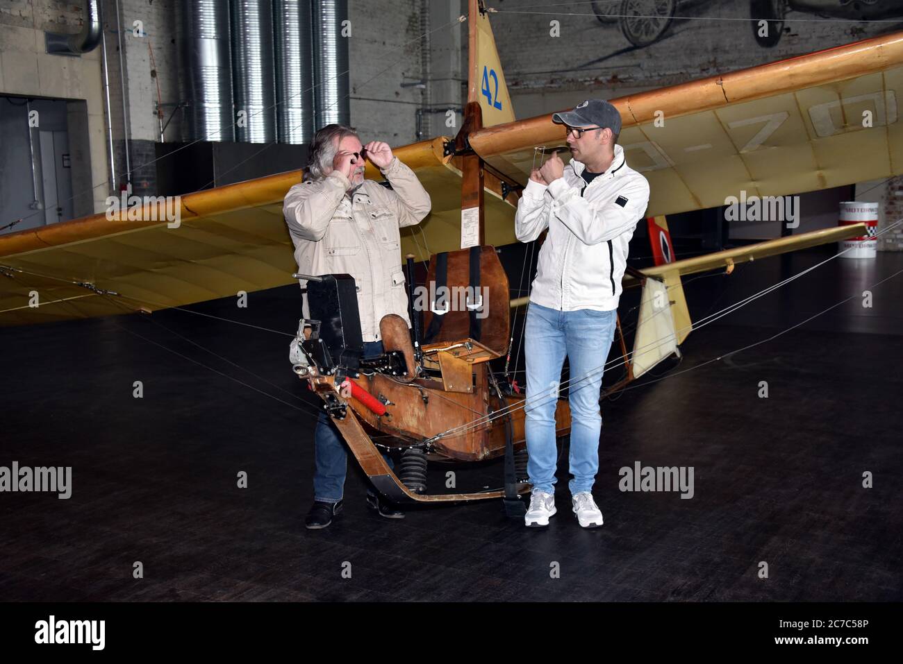 15 July 2020, North Rhine-Westphalia, Cologne: Musician Tommy Engel and comedian Marc Metzger, l-r, pose on a school glider SG 38, glider from 1942 during the presentation of the safety and hygiene concept of the dinner show 'Weihnachtsengel' which will be shown from 20.11.2020. Photo: Horst Galuschka/dpa/Horst Galuschka  dpa Stock Photo