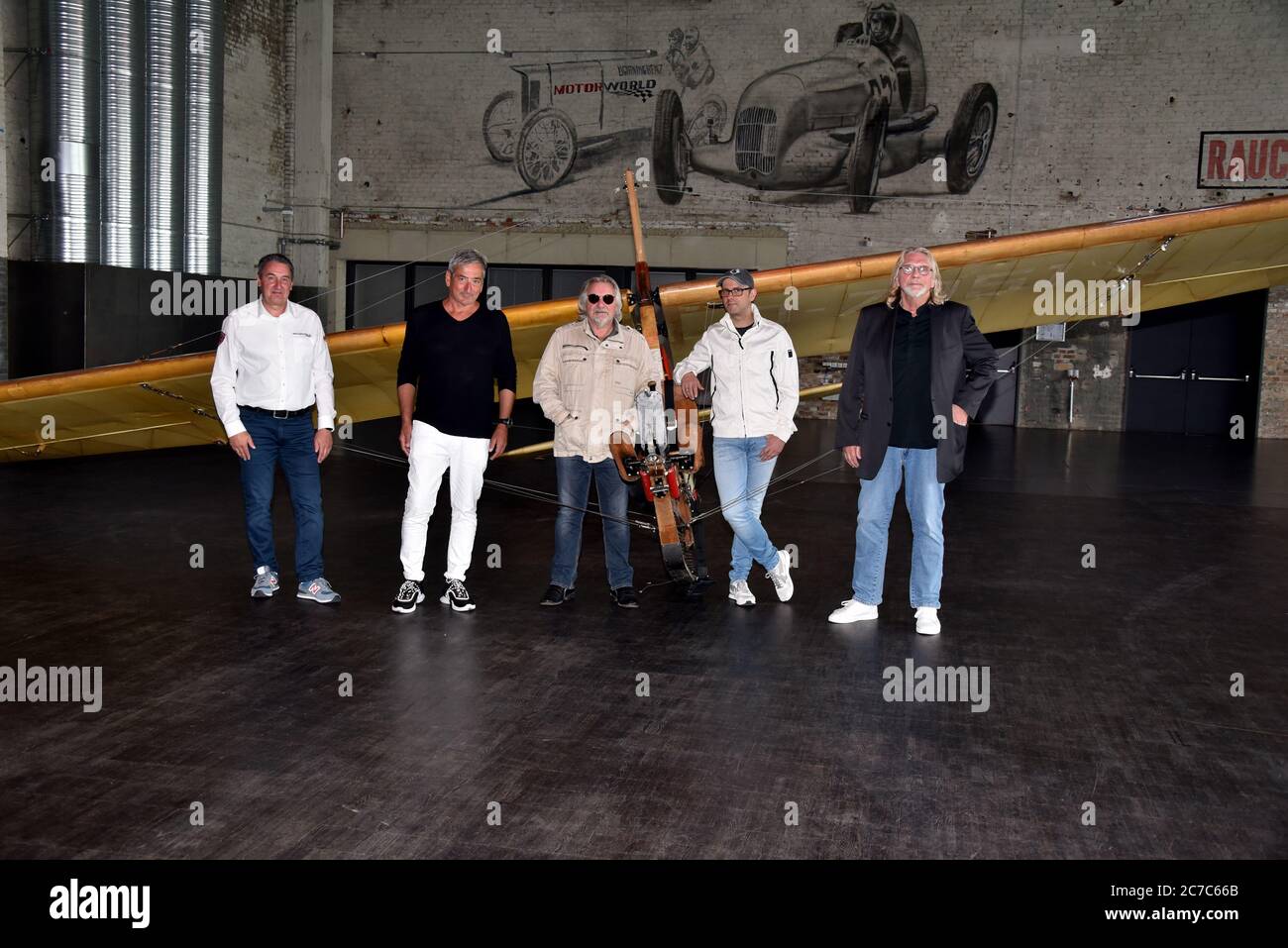 Cologne, Germany. 15th July, 2020. Dirk Strohmenger, Center- and Facility Manager at MOTORWORLD, Jürgen Walter, Catering Auftischt, musician Tommy Engel, comedian Marc Metzger and musician Jürgen Fritz pose on a school glider SG 38, glider from 1942, at the presentation of the safety and hygiene concept of the dinner show 'Weihnachtsengel' which will be shown from 20.11.2020. Credit: Horst Galuschka/dpa/Alamy Live News Stock Photo