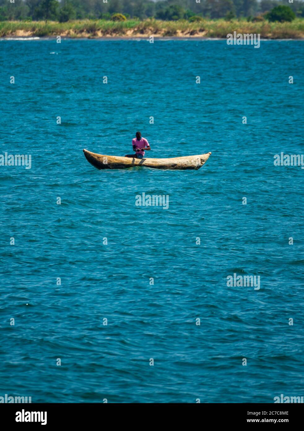 Unrecognizable fisherman fishing over wooden canoe, lake Malawi Stock Photo