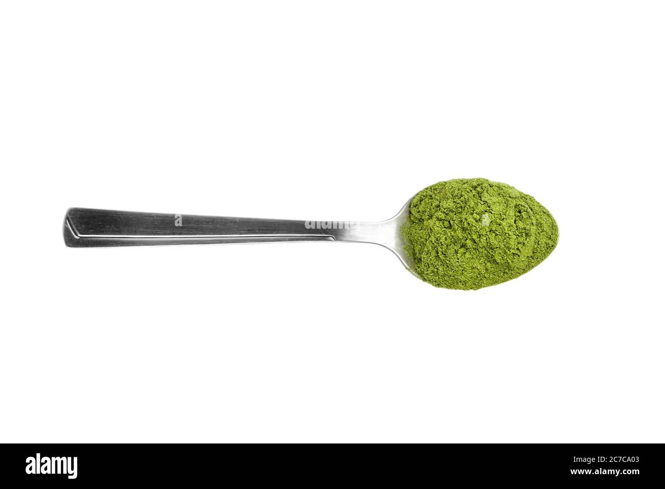 Green freeze dried wheatgrass powder in steel teaspoon isolated on