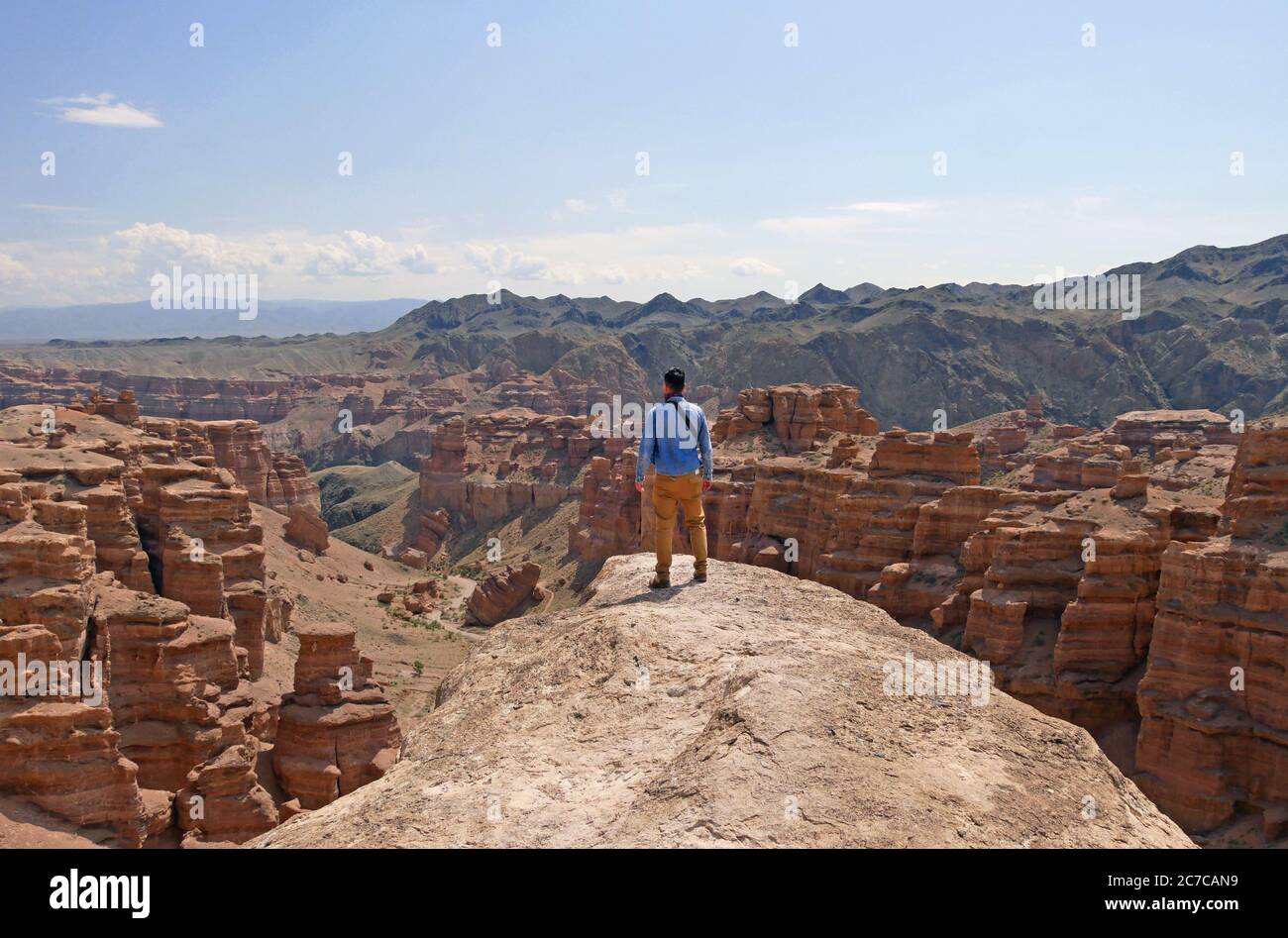Man standing on a rock overseeing the magnificent landscape of Charyn Canyon, Kazakhstan Stock Photo
