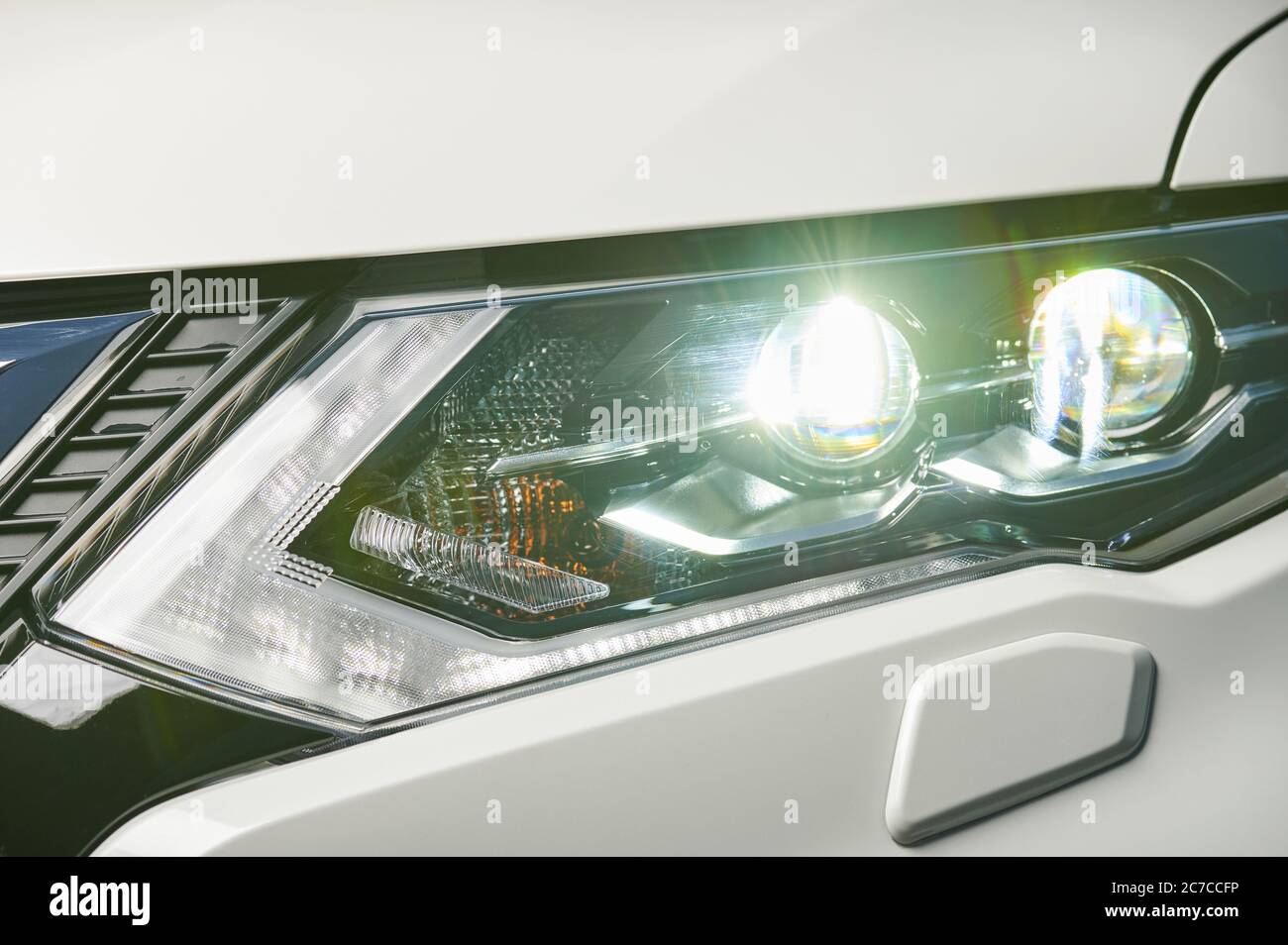 Front car headlight with lamp on close up view Stock Photo