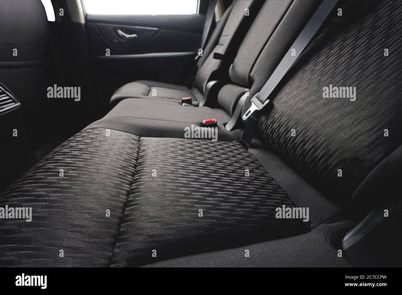 Close up of clean cloth car back seat with safety belts Stock Photo