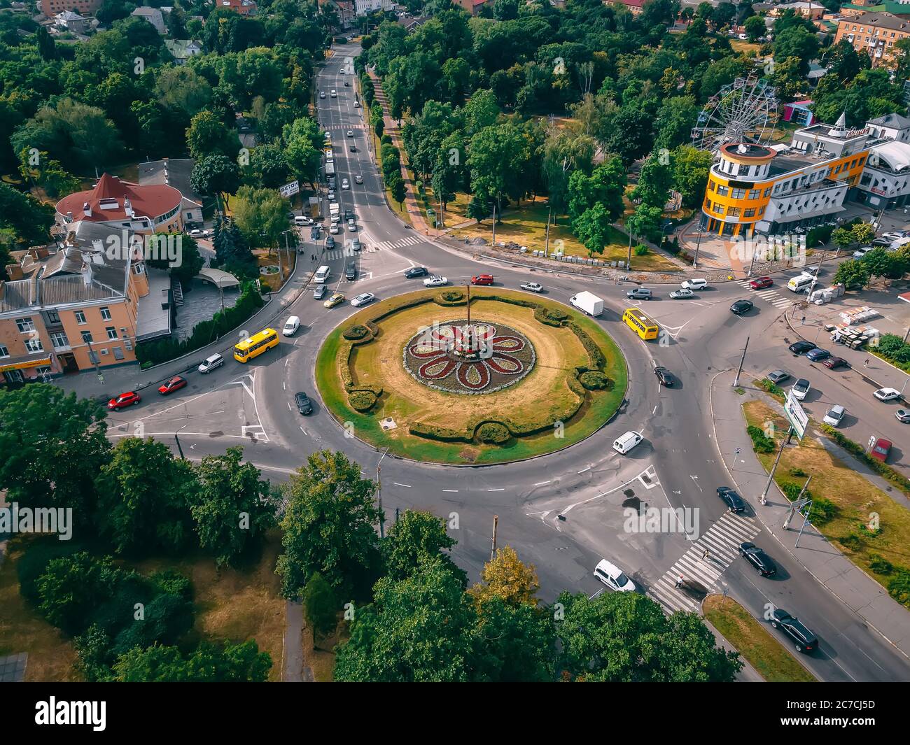 Aerial view of roundabout road with circular cars in small european city at summer afternoon, Kyiv region, Ukraine Stock Photo