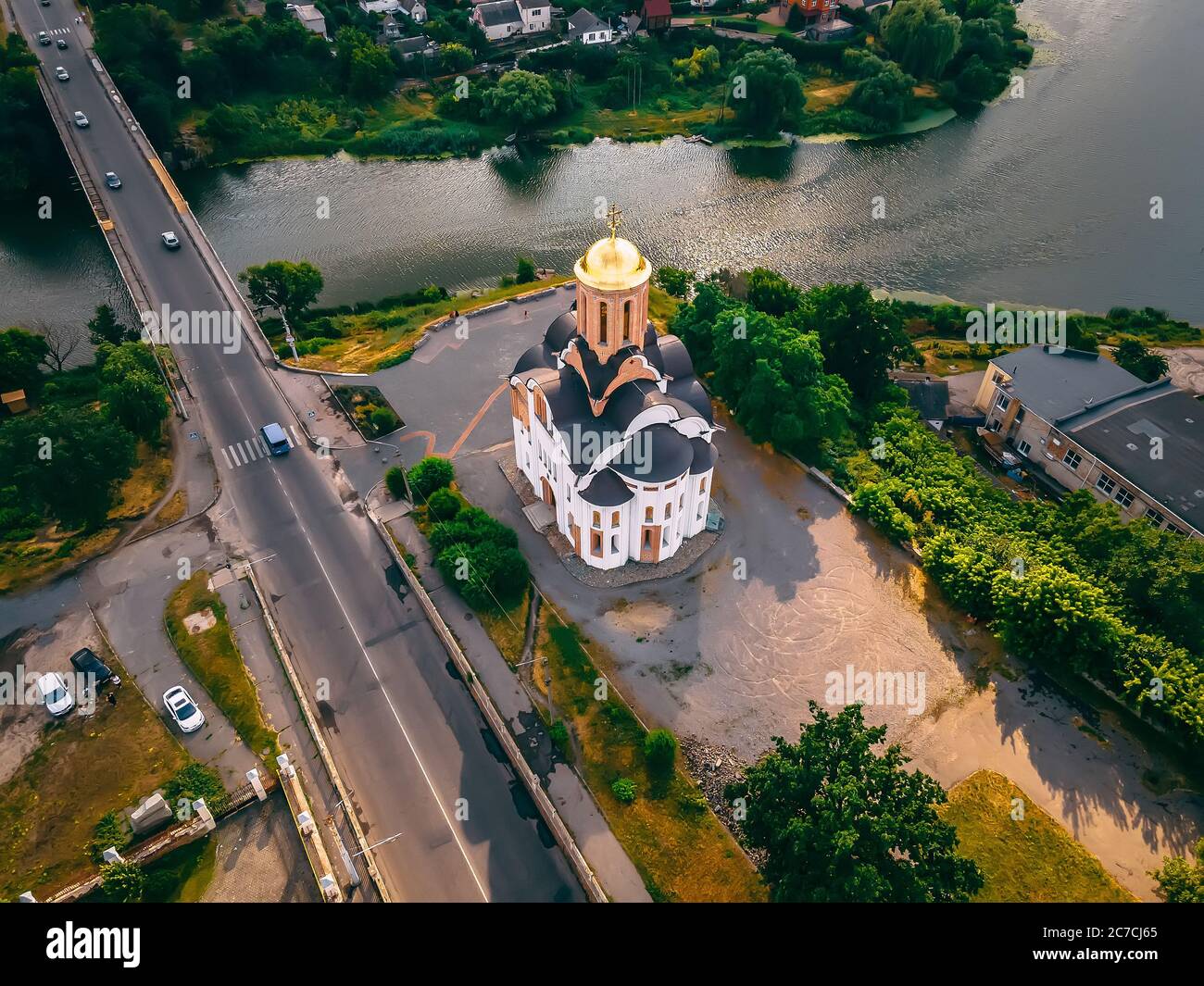 Aerial view of old church near river and bridge in small european city at summer day, Kyiv region, Ukraine Stock Photo