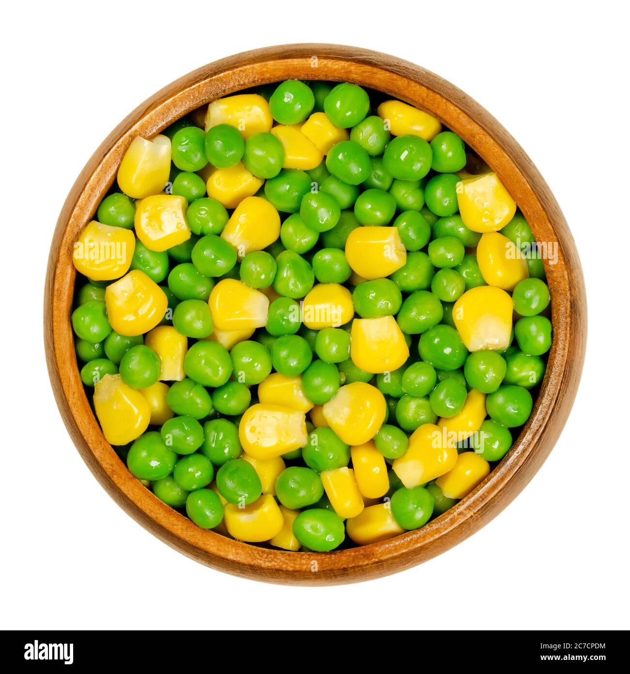 Green peas and corn in wooden bowl. Mixed vegetables. Seeds of pod fruit Pisum sativum and blanched yellow vegetable maize, Zea mays. Stock Photo