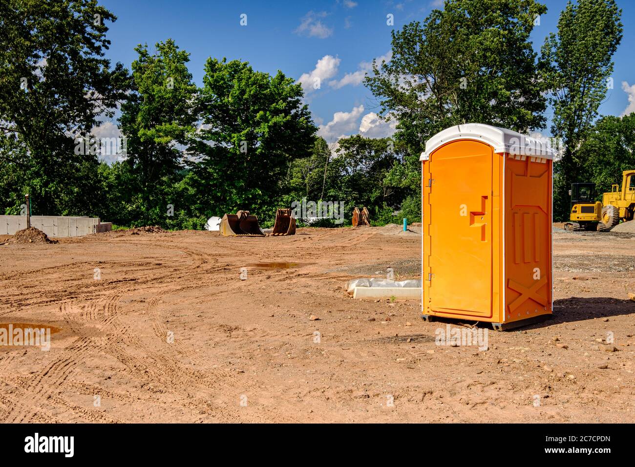 Porta Potty on an active construction site with earth moving equipment