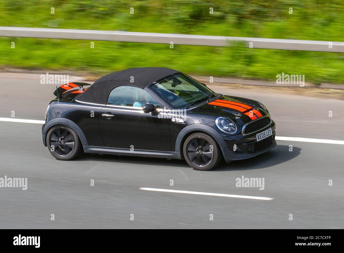 2014 black red Mini Roadster Cooper SD; Vehicular traffic moving vehicles, cars driving vehicle on UK roads, motors, motoring on the M6 motorway highway network. Stock Photo