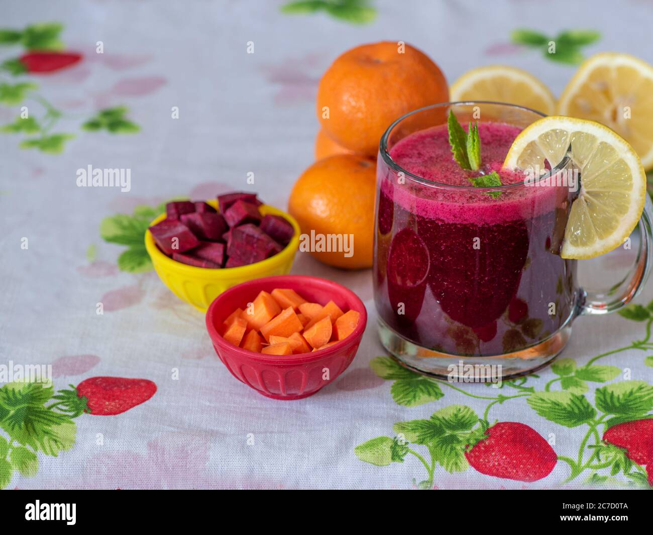 Colorful still life portraying a juice made of fruits and roots over