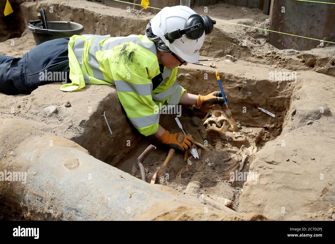 Archaeologist Clare McCabe from the Trams to Newhaven project excavating human remains, which could date back as far as 1300, from the graves of South Leith Parish Church whose medieval graveyard extends beneath the road surface of Constitution Street, Leith. Stock Photo