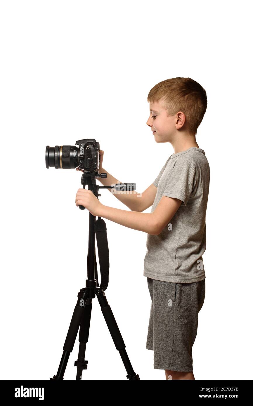 Schoolboy shoots video on DSLR camera. Side view. White background, isolate Stock Photo