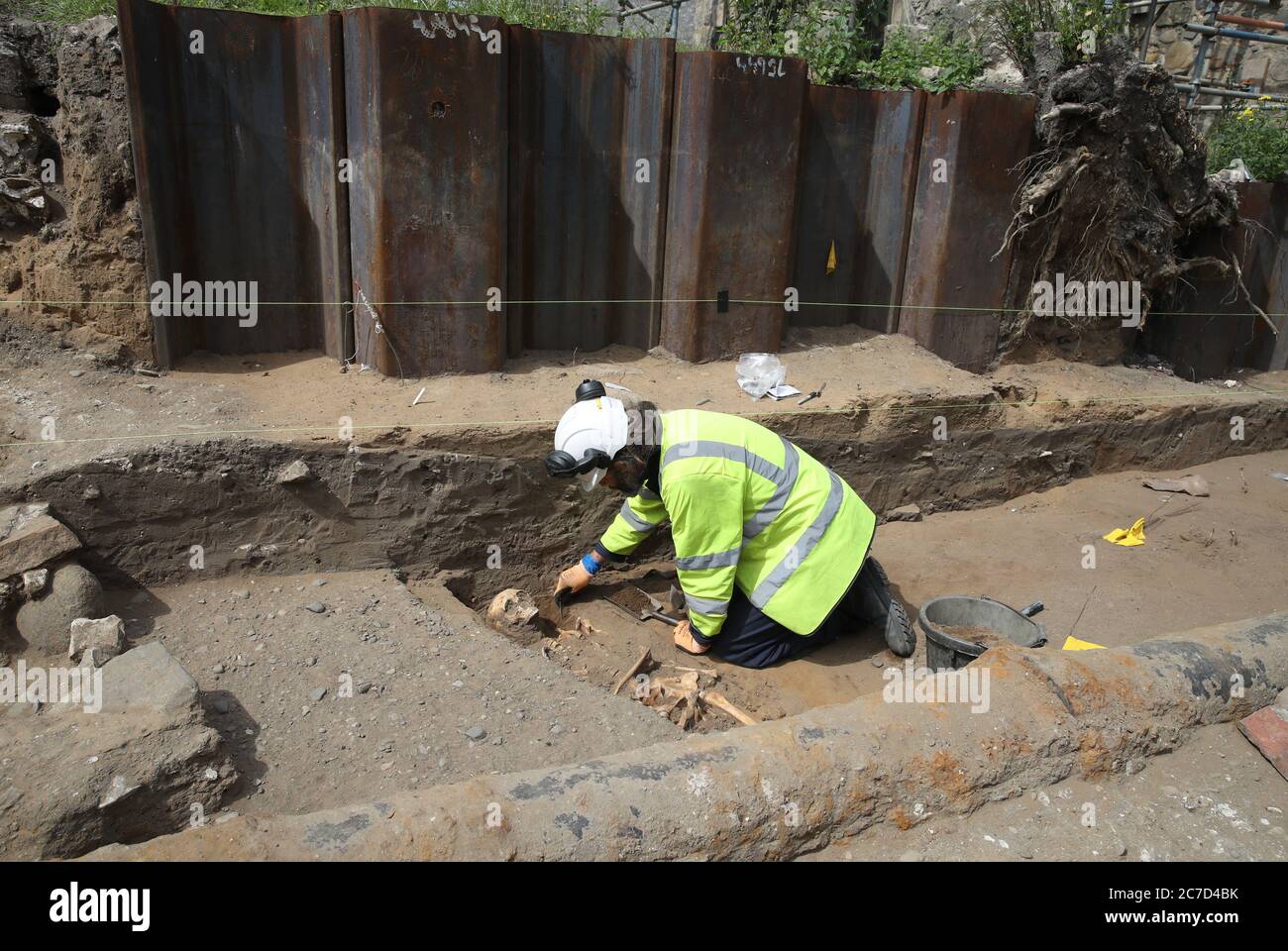 An Archaeologist from the Trams to Newhaven project excavating human remains, which could date back as far as 1300, from the graves of South Leith Parish Church whose medieval graveyard extends beneath the road surface of Constitution Street, Leith. Stock Photo