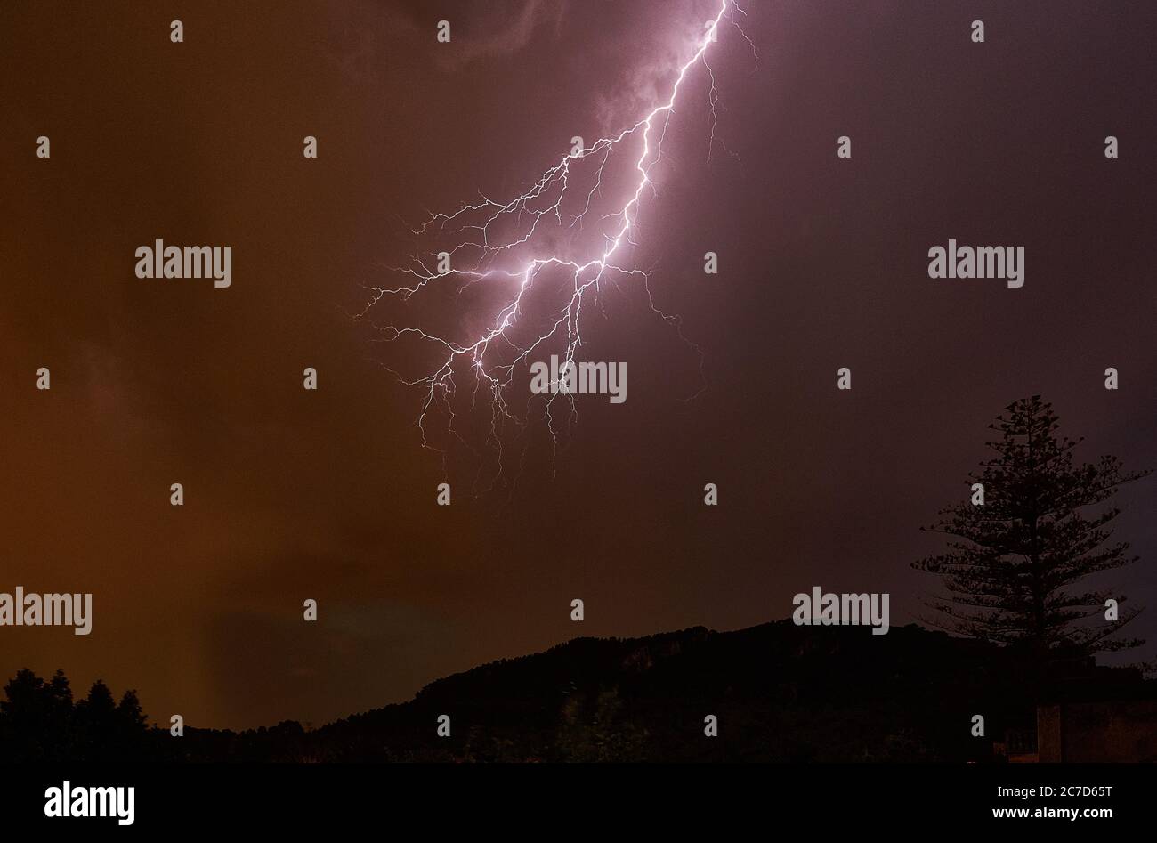 Low angle shot of the lightning in the night sky and mountains with ...