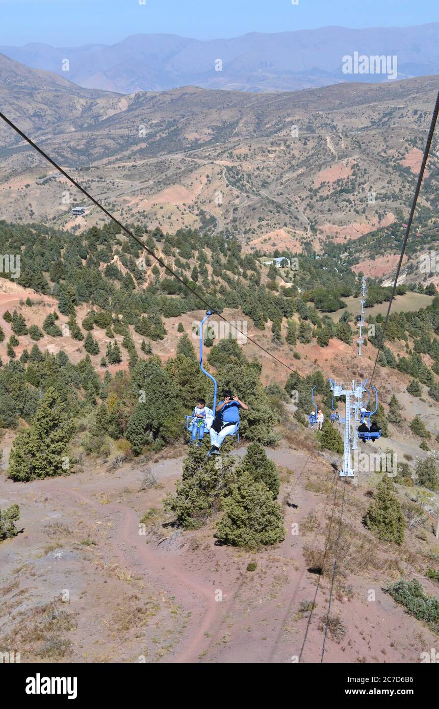 People climb the cable car up the mountain. On a Sunny summer day. Mountains of Uzbekistan, Beldersay Stock Photo