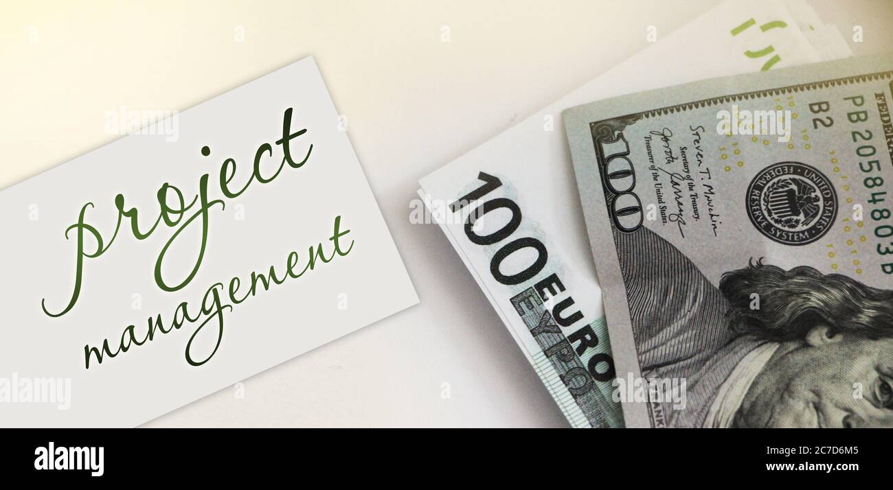 PROJECT MANAGEMENT on card ,100 dollar bill and 100 Euro bill. Business concept Stock Photo