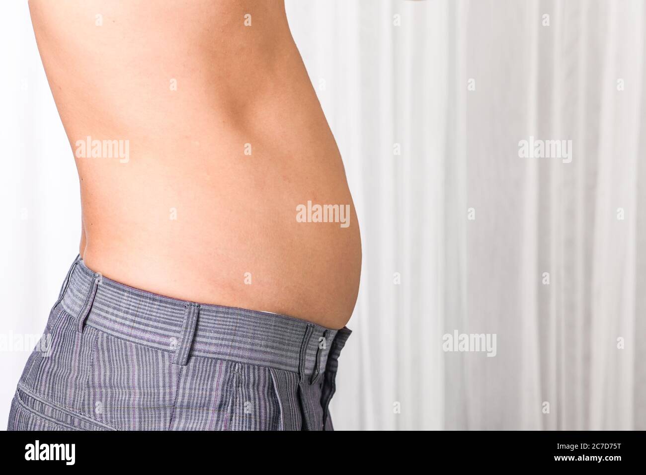 Skinny man with belly fat pulled have pulled their abdominal muscle Stock  Photo - Alamy