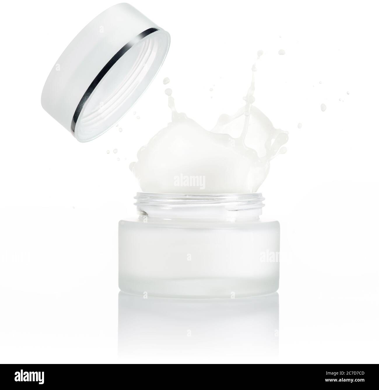 moisturizer cream splashing out of a small jar isolated on white Stock Photo