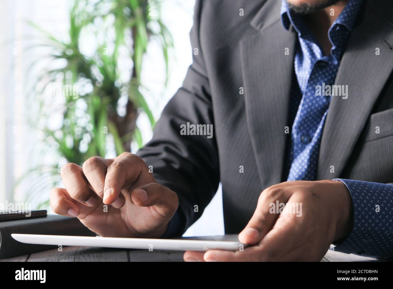man's hand working on digital tablet at office desk, using self created ...