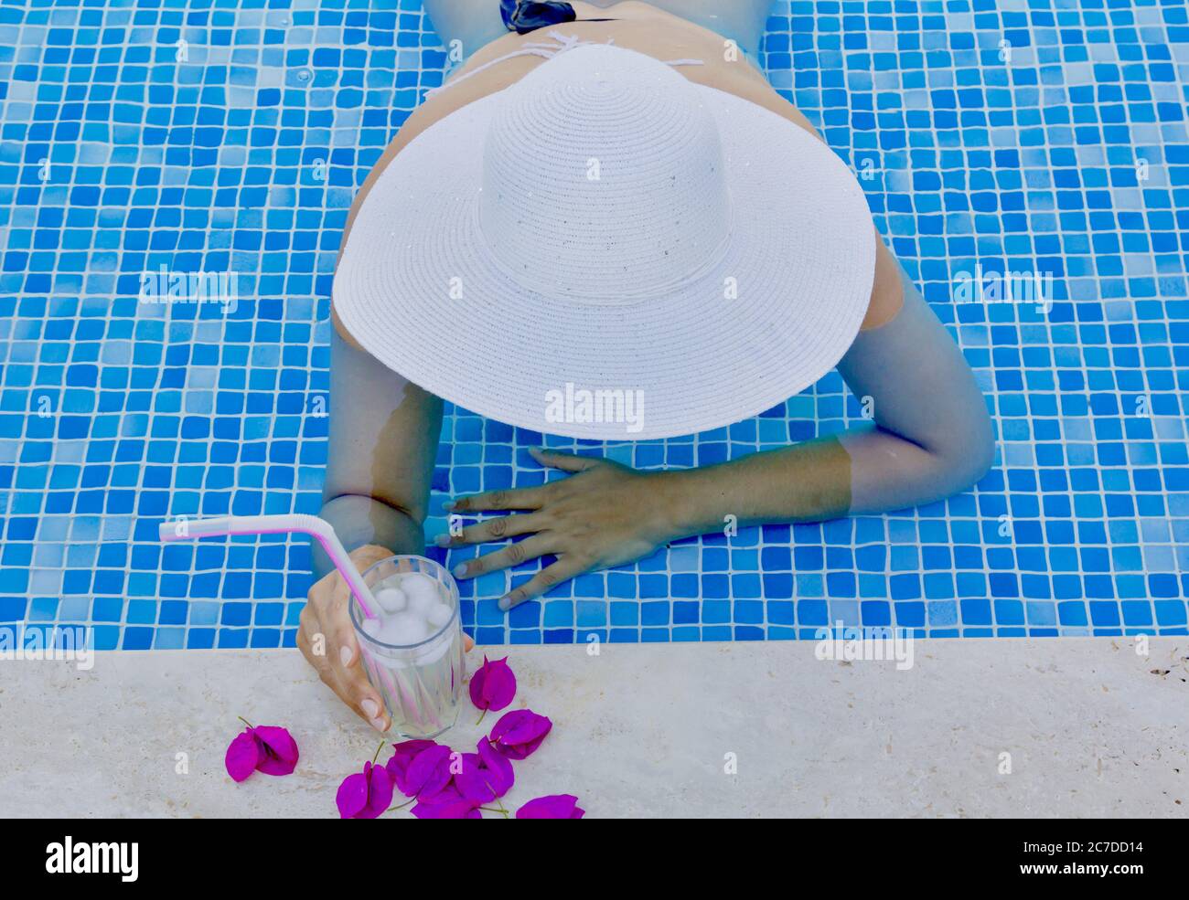 young woman in a white hat relaxing in the pool Stock Photo - Alamy