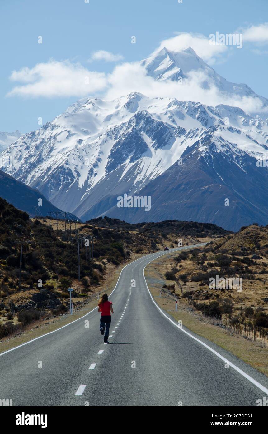 Girl running on the road to the Mount Cook, South Island, New Zealand, Mount Cook National Park Stock Photo