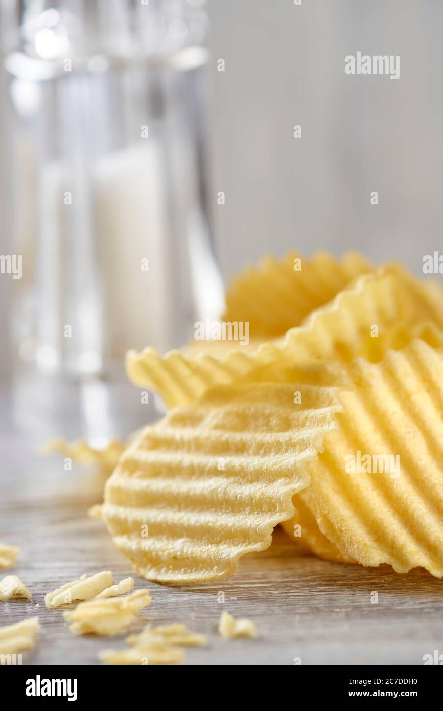 A pile of temptingly crunchy potato chips lies on the table. Junk food