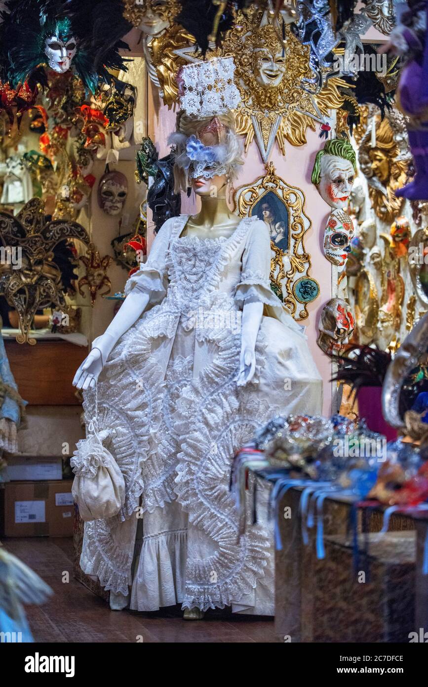 Ornate carnival mask among colorful feathers in Venice, Italy. A display of Masquerade Ball Masks and Venetian Mask on sale in Bardolino Lake Garda Ve Stock Photo