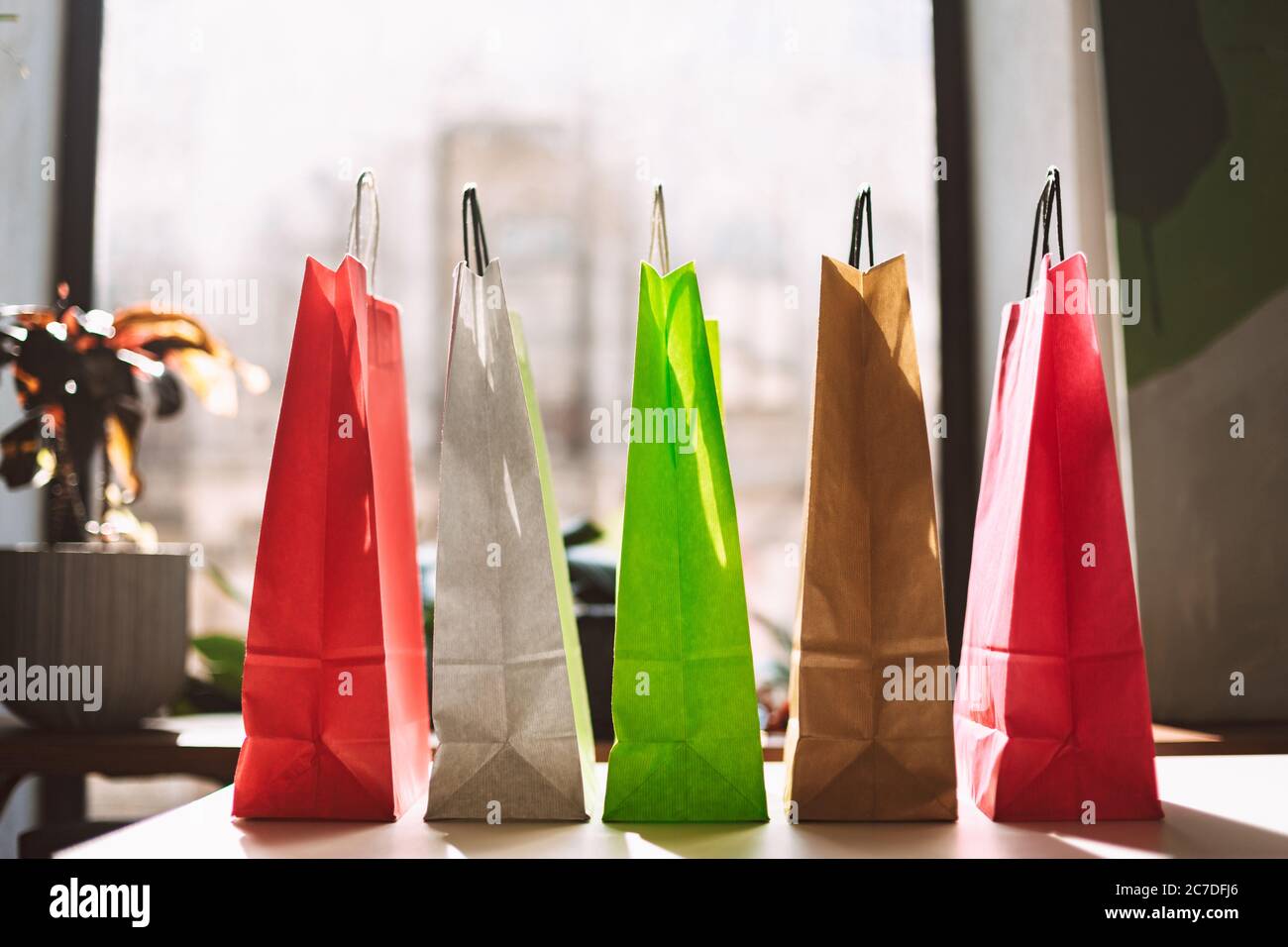 Close up colorful shopping bags on table with big window on background isolated Stock Photo