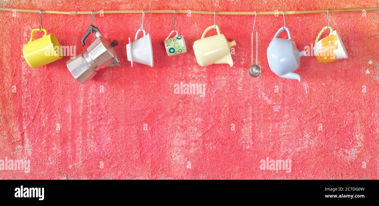 coffee pots and coffee cups hanging on a rustic wall, panorama format