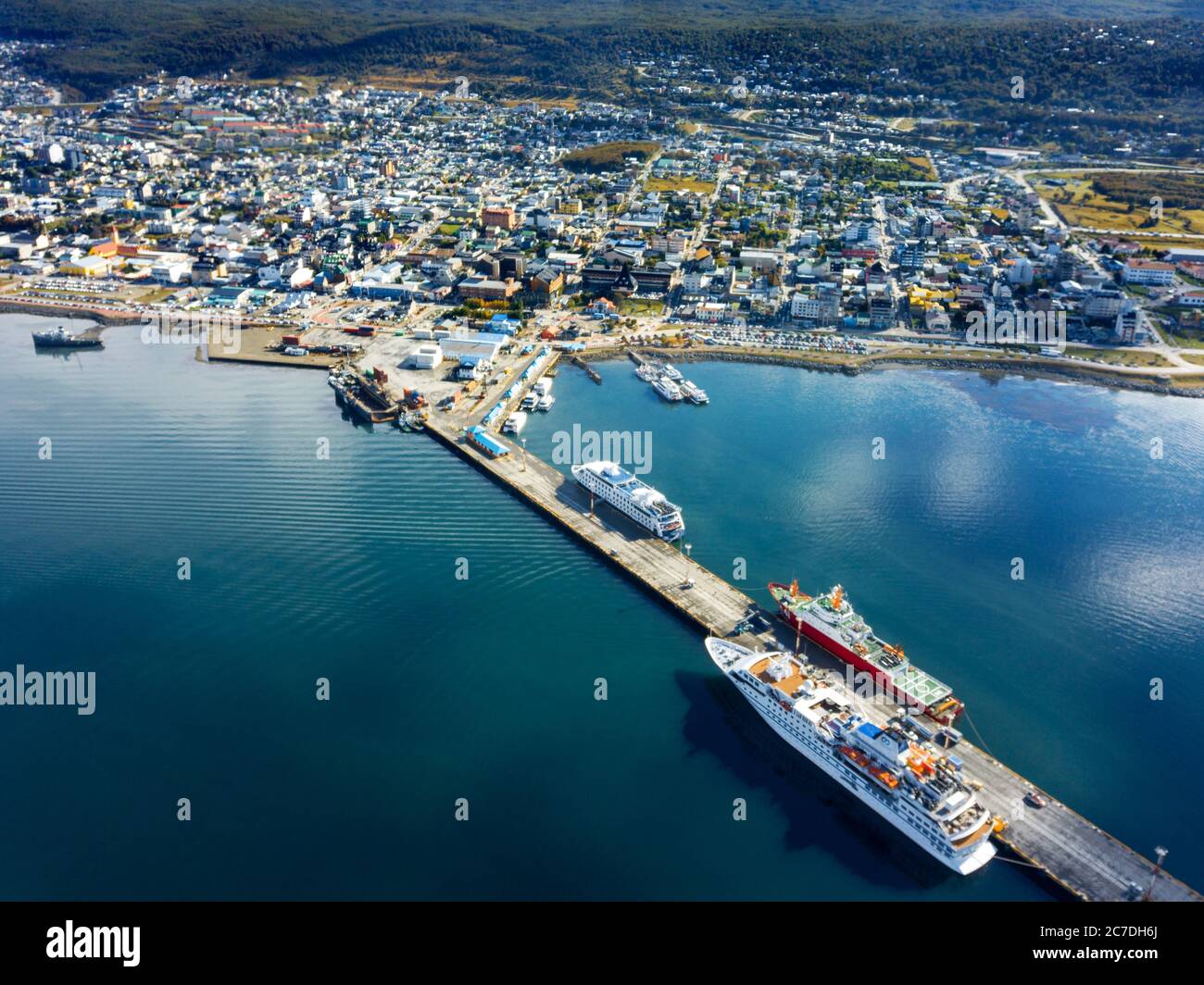 Drone aerial view of Ushuaia harbour seafront and mountains and the city in the back Ushuaia, Tierra del Fuego, Argentina. Stock Photo