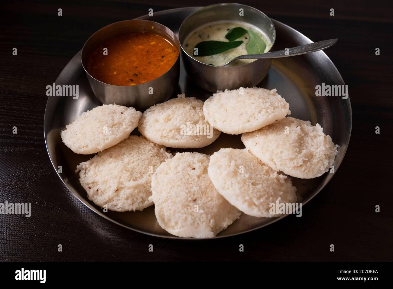 a lower angle view of south karnataka homemade rave idly, sambar & chutney isolated on wooden table Stock Photo