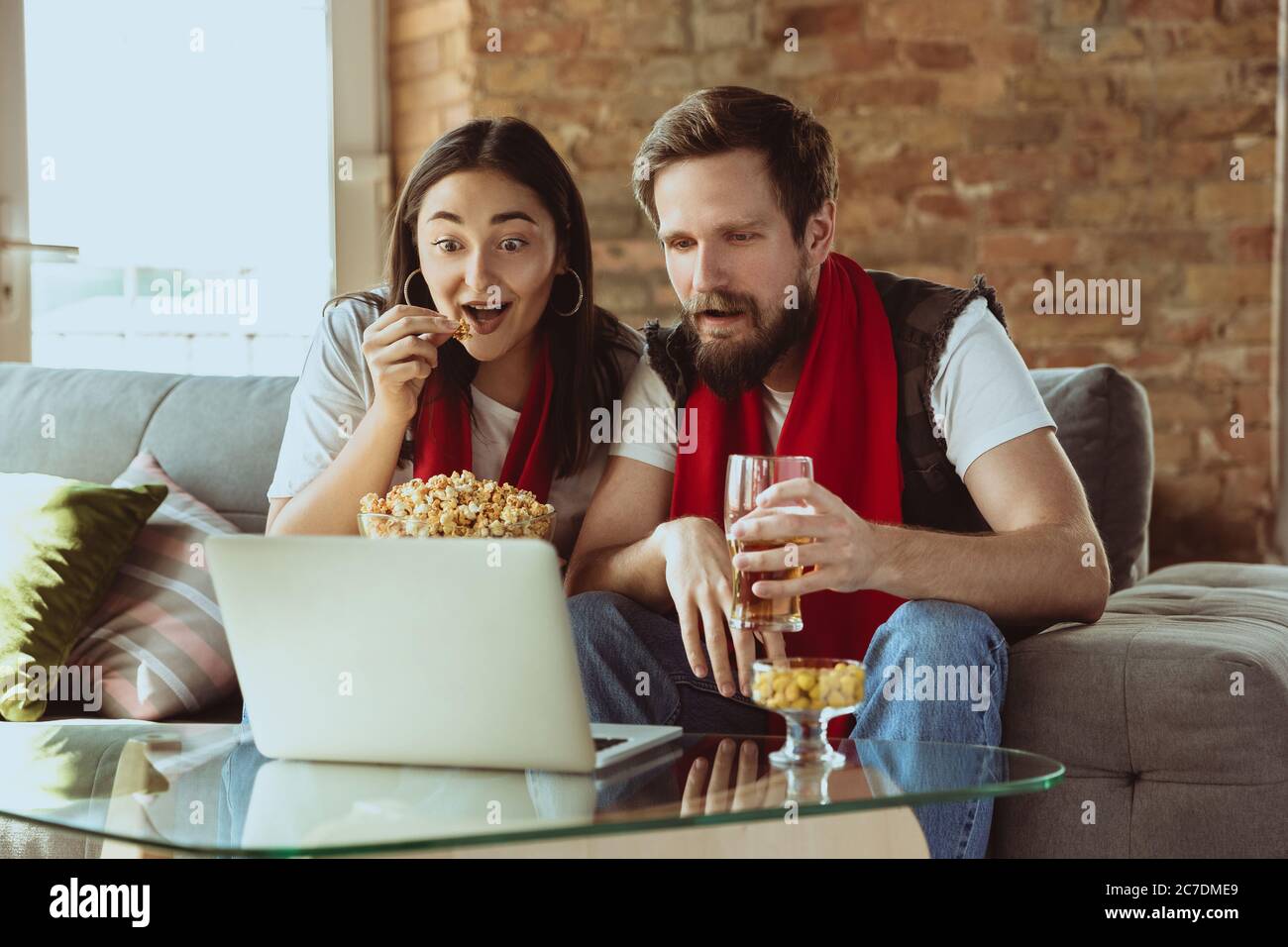 Excited football fans watching sport match at home, remote support of favourite team during