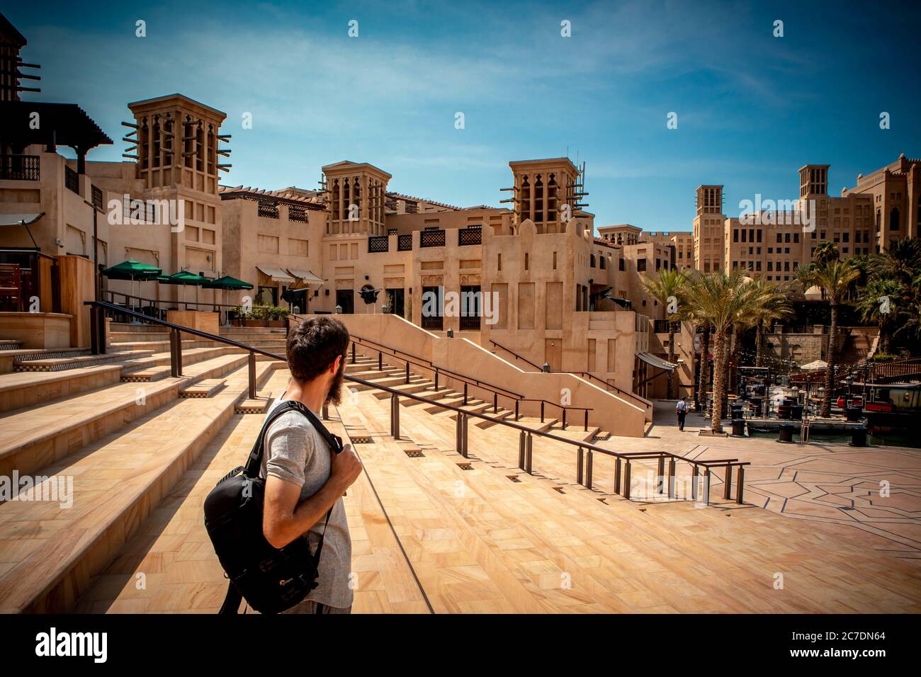 Person standing on the stairs of Madinat Jumeirah Resort under a clear blue sky in Dubai, UAE Stock Photo