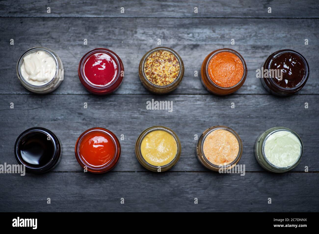 Large collection of sauces and spiced spreads in small jars as mayo ketchup mustard soy sauce