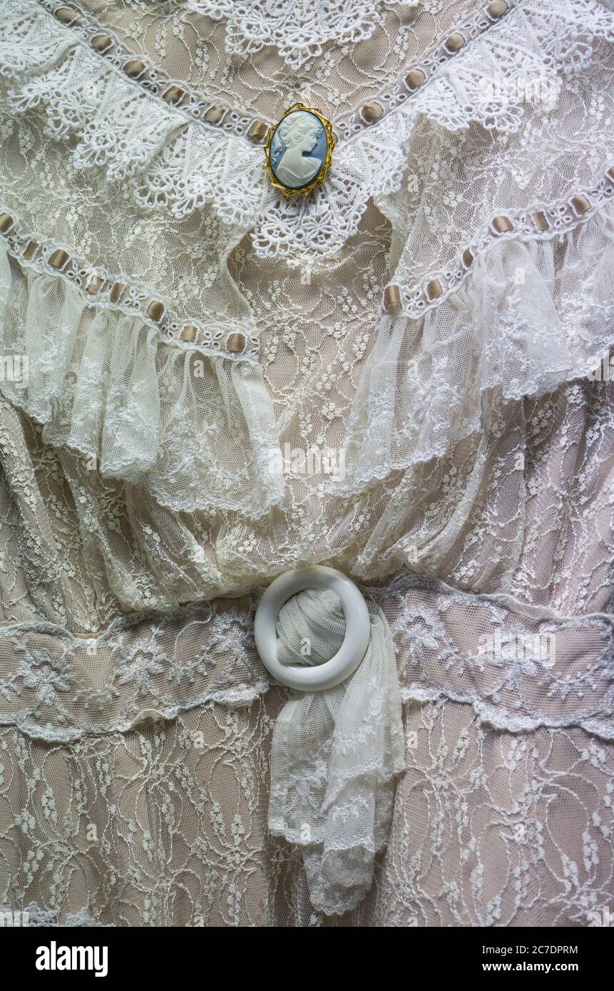 Old Fashioned Antique White Lace Victorian Dress with Cameo Stock Photo