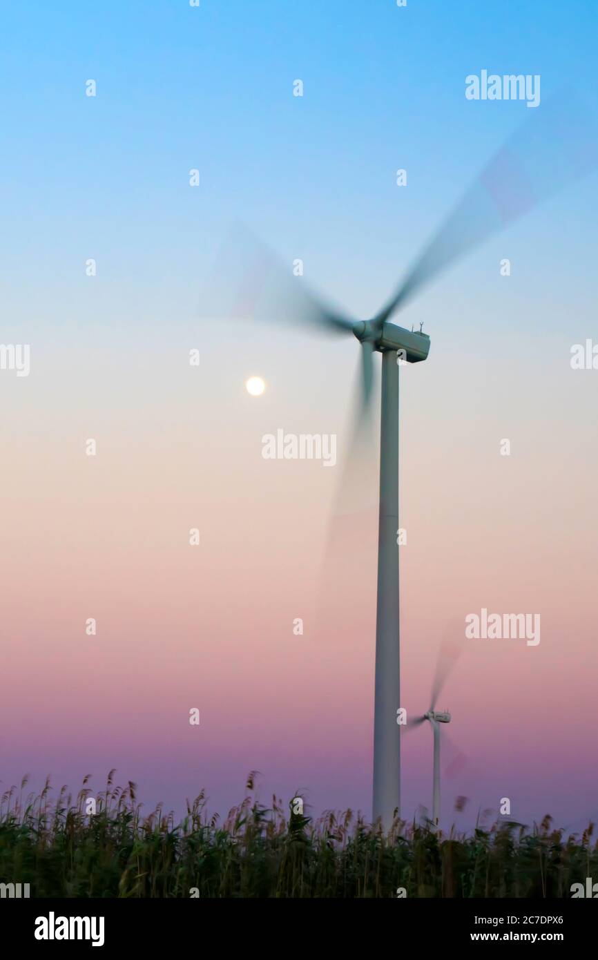 Wind turbine and sunset sky background Stock Photo - Alamy