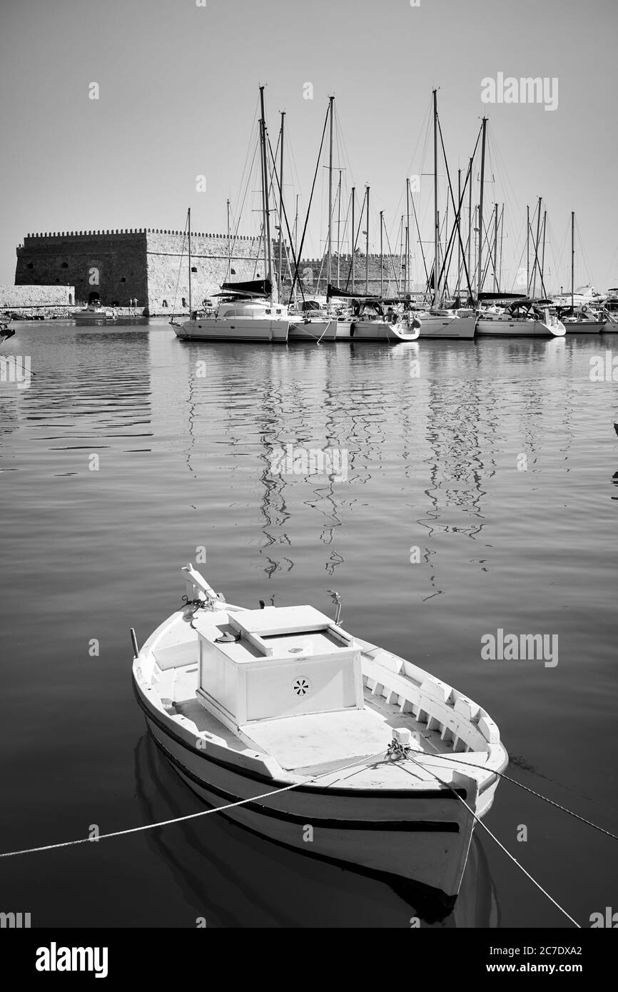 Small fishing boat in the harbour near Koules Fortress in Heraklion, Crete, Greece. Greek scenery, black and white photography Stock Photo