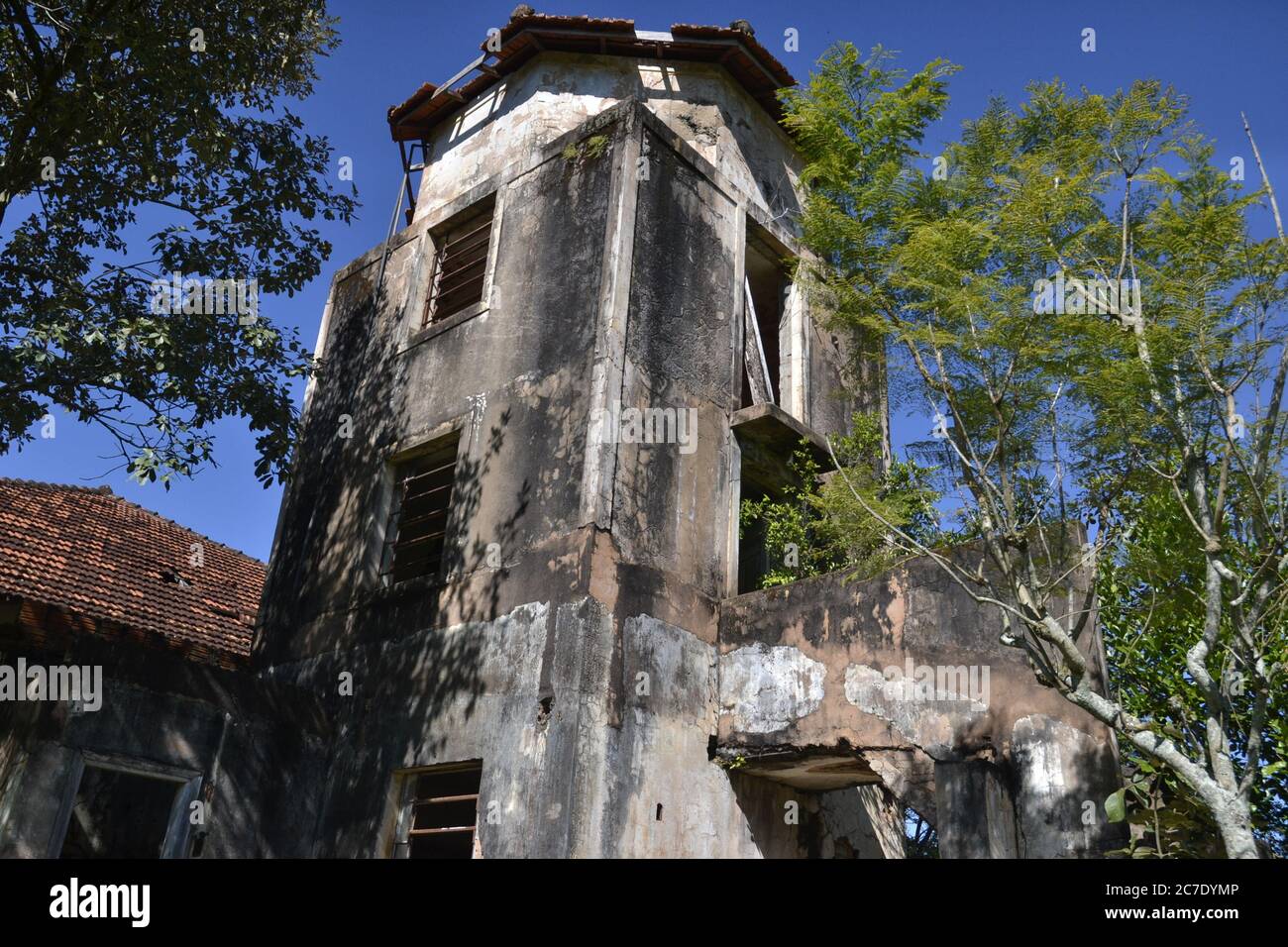 Tower. Abandoned hotel tower in the interior of Brazil, with vegetation and roof, old water tank, Brazil, South America, bottom-up view, with blue sky Stock Photo