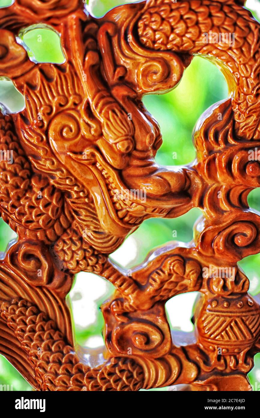 Closeup shot of a brown wooden carving of a Chinese dragon in Malaysia Stock Photo