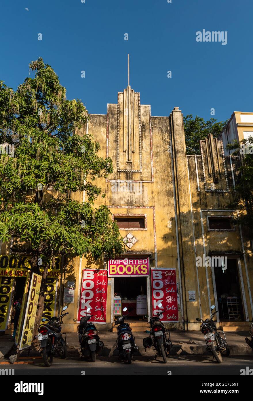 Pondicherry, India - February 2020: An old, faded yellow French art deco building running a book sale inside. Stock Photo