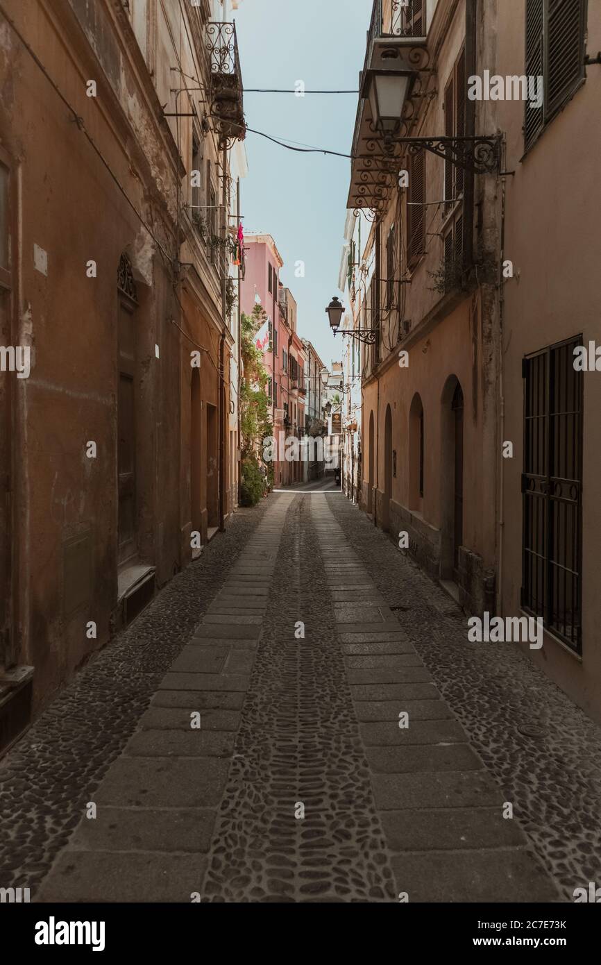 Vertical shot of an empty alleyway in the middle of buildings Stock Photo