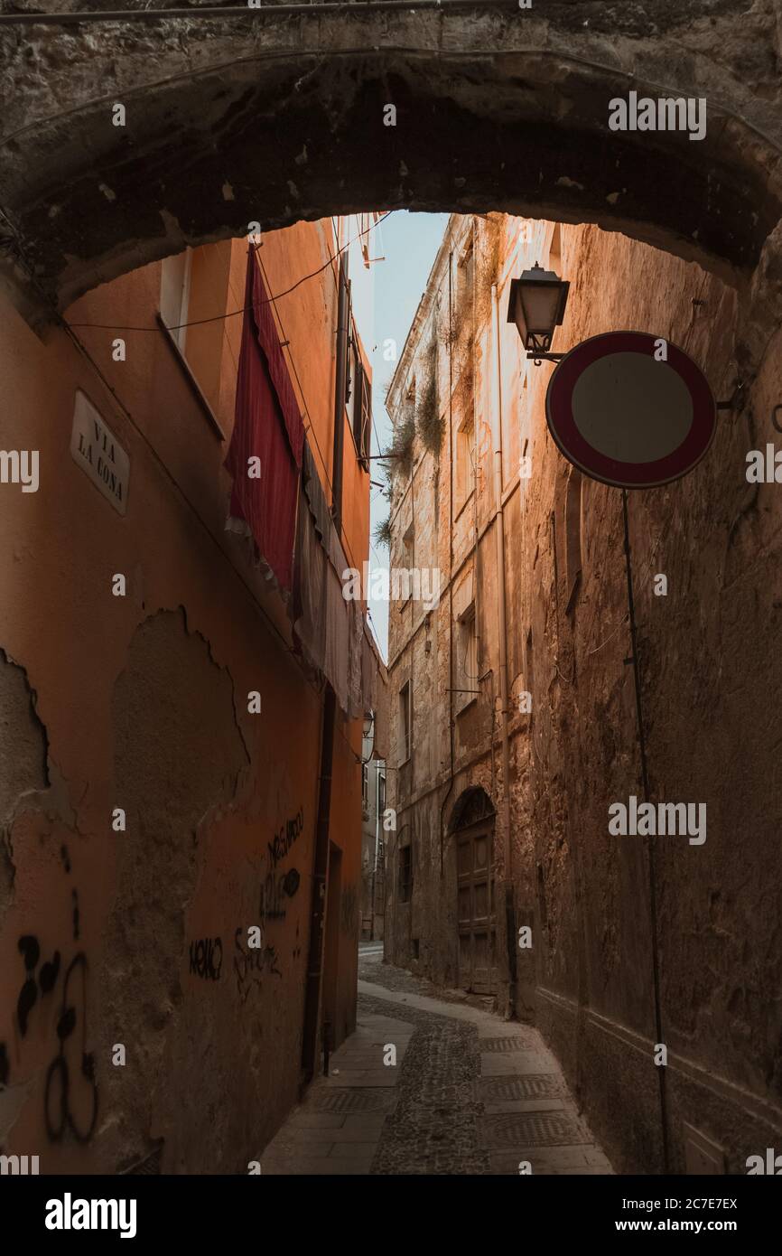 Vertical shot of a narrow alleyway in the middle of buildings Stock Photo