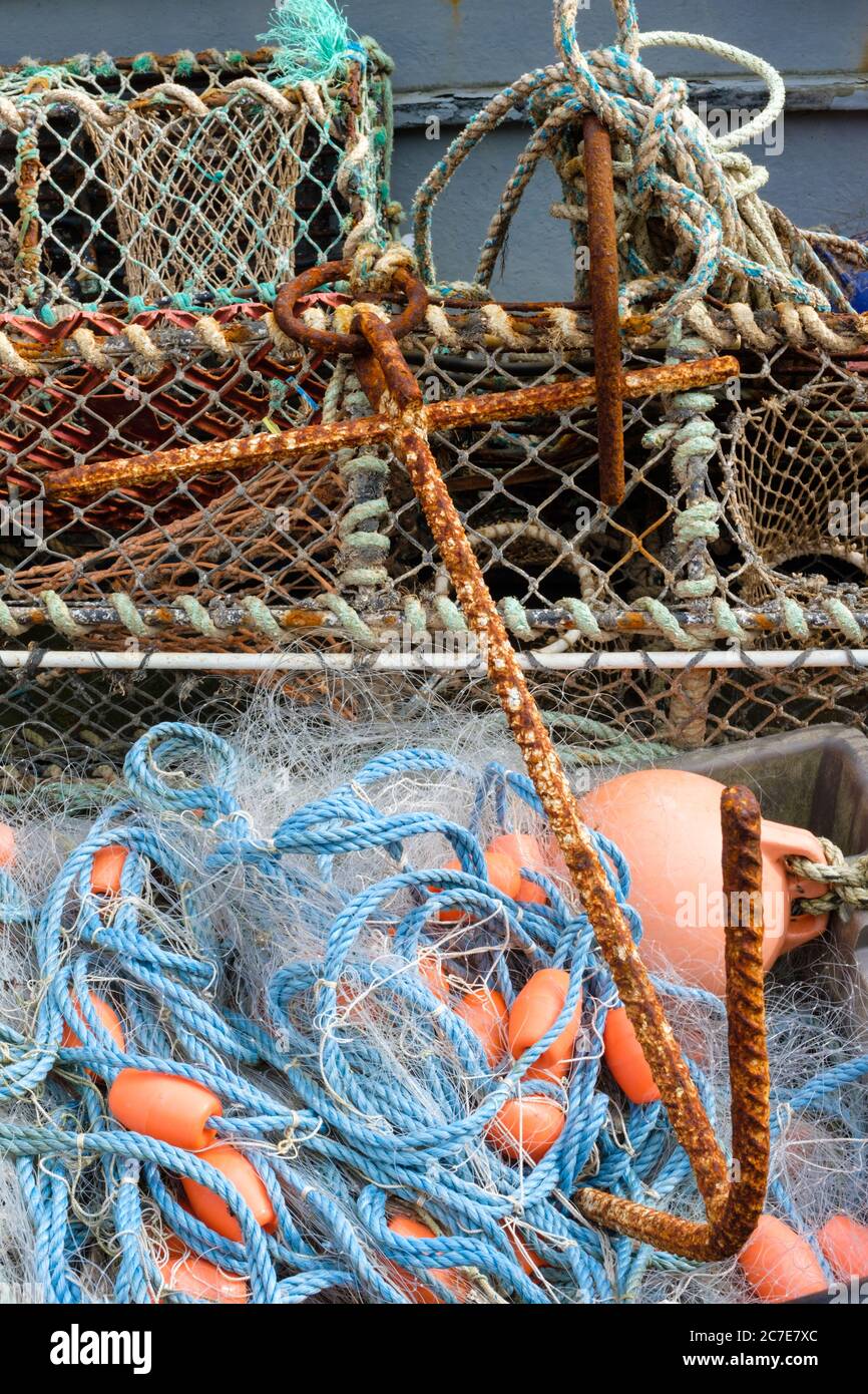 Fishing nets and tackle including lobster and crab pot, laying in a rowing boat. England, UK Stock Photo