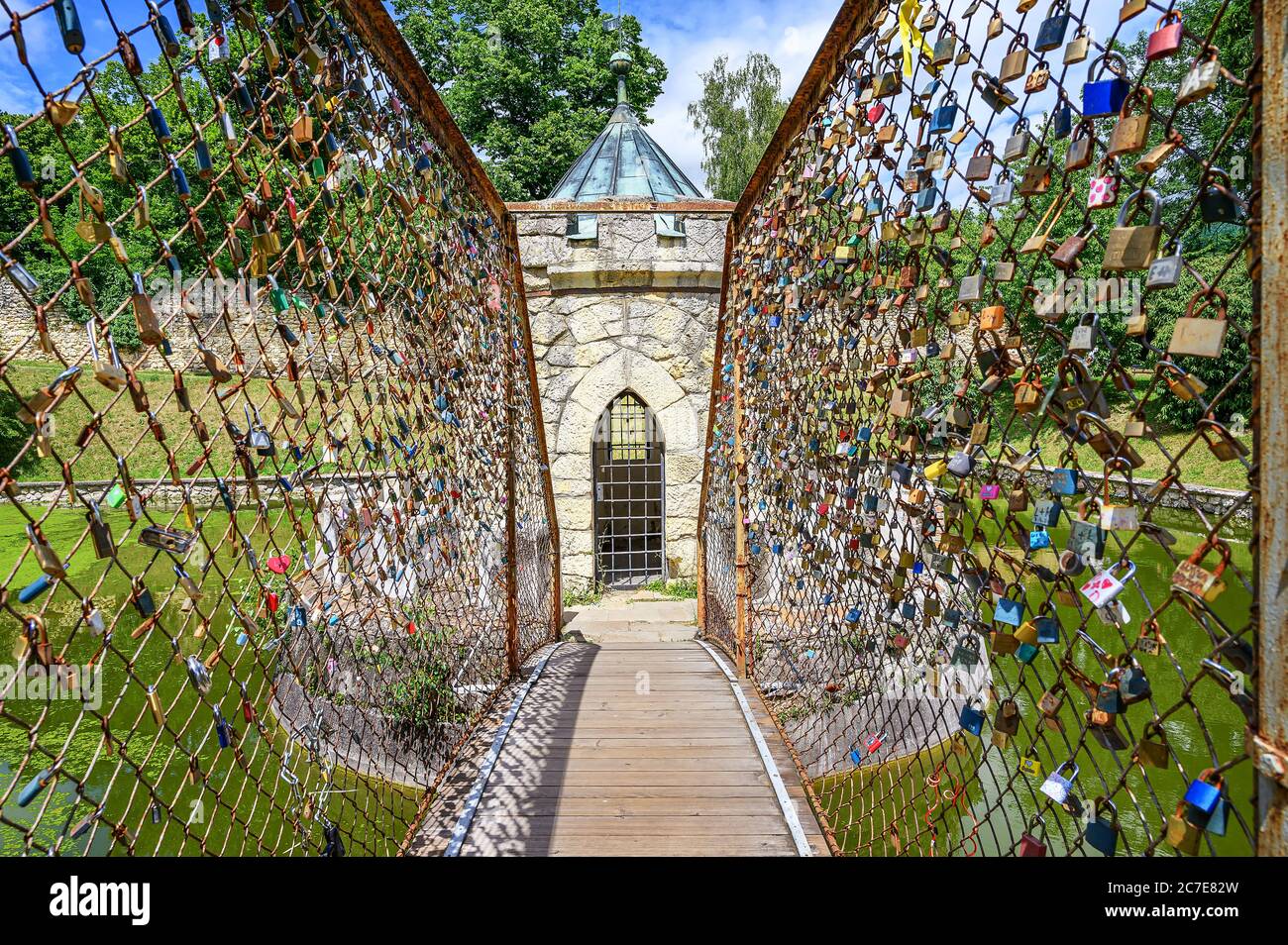 Bridge with many Love locks leading to small Roundhouse in pond in Bojnice castle park (Bojnice, Slovakia) Stock Photo
