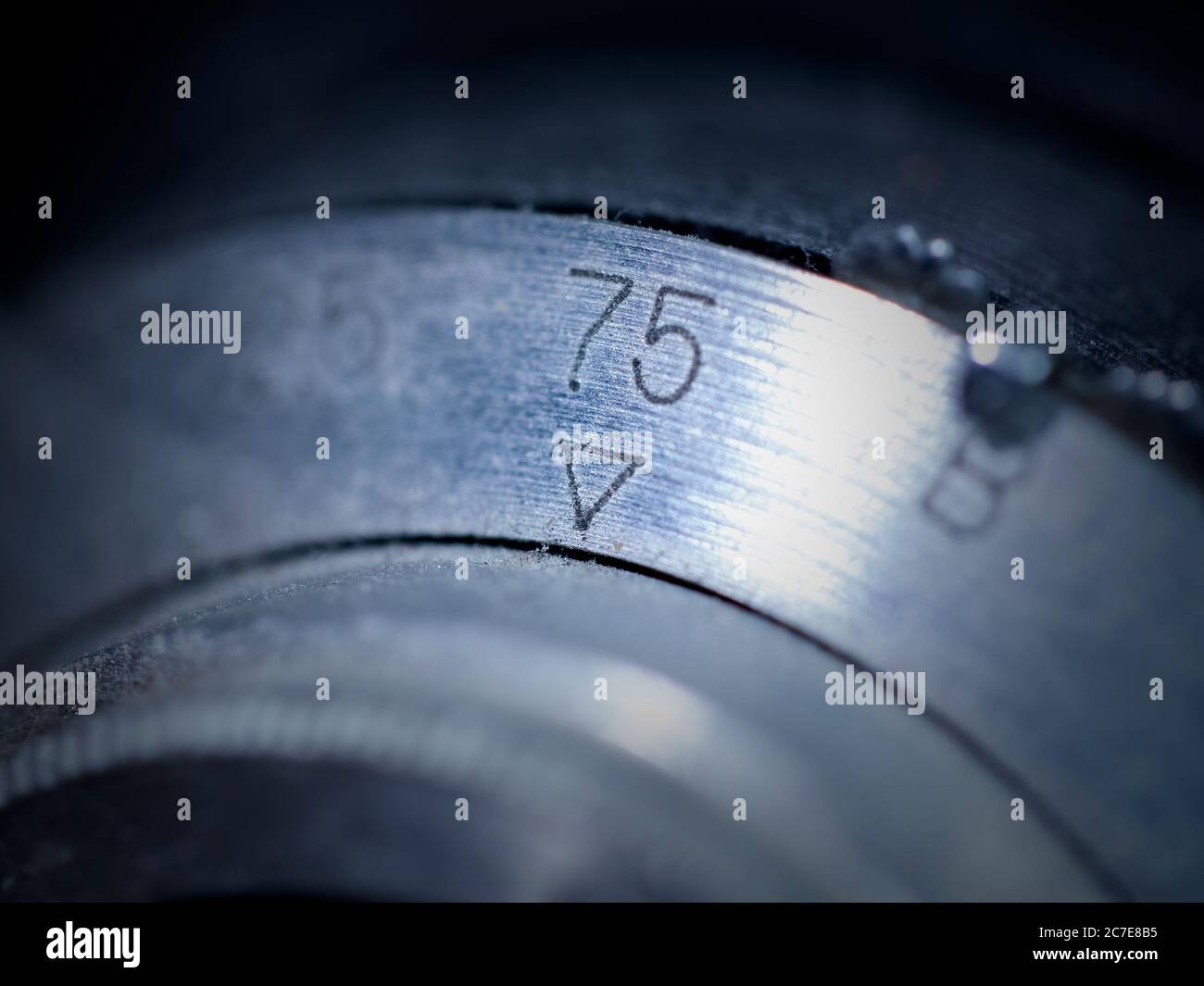 Macro shot of the number, '75' on the end of an old-school camera lens. Stock Photo