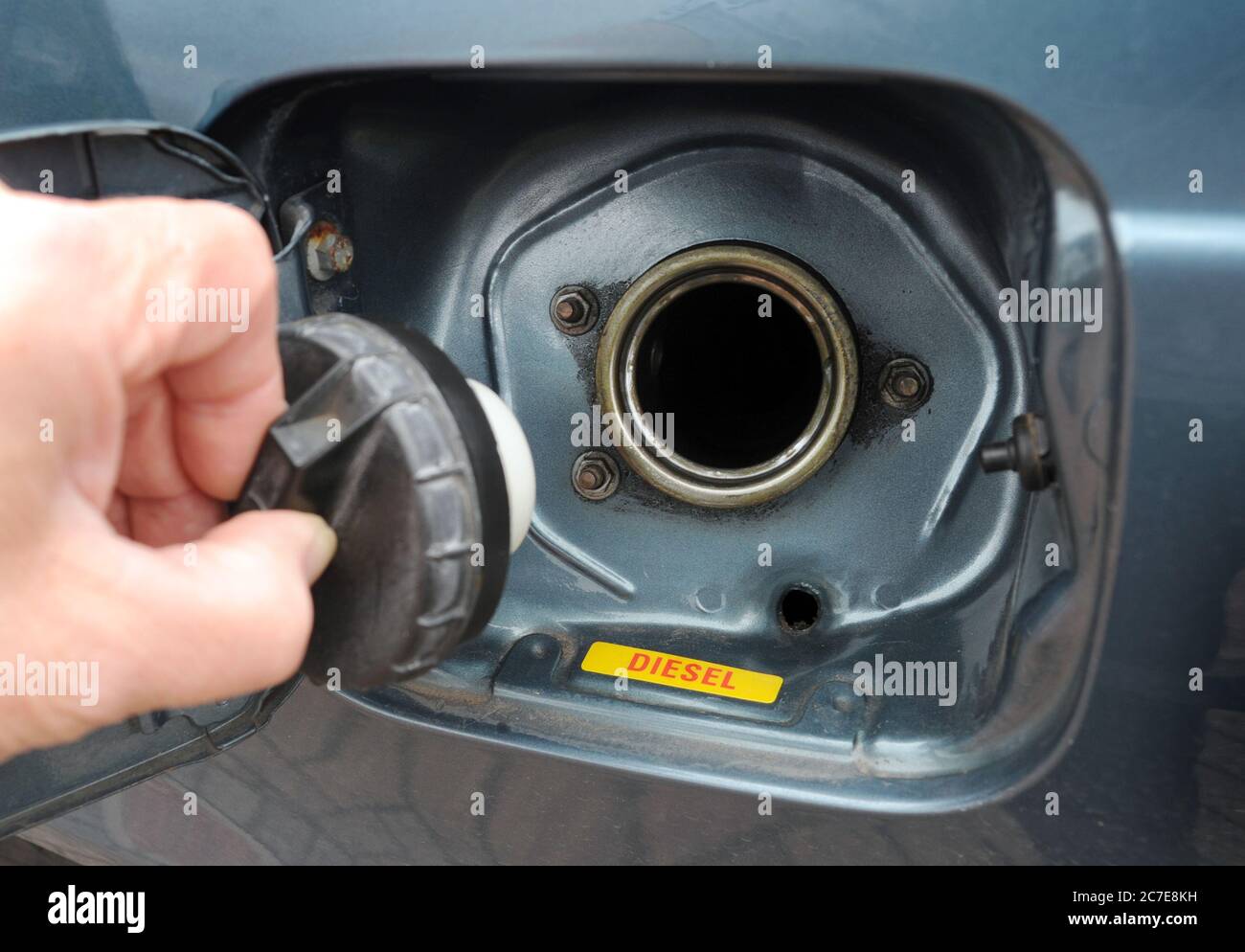 FUEL CAP BEING REMOVED FROM OLDER CAR DIESEL FUEL TANK RE EMISSIONS ELECTRIC CARS DIRTY ENGINES THE ENVIRONMENT OLD CARS ETC UK Stock Photo