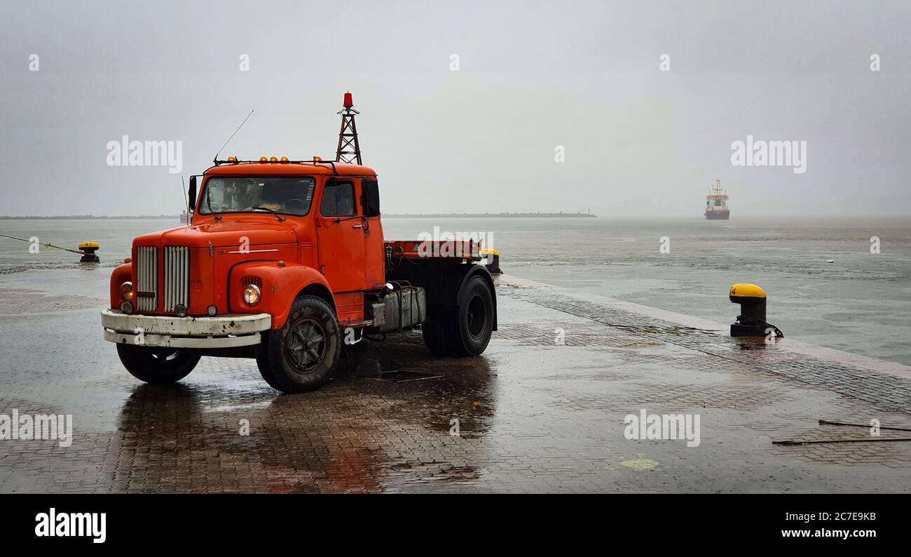 Old red truck next to the sea in Uruguay Stock Photo